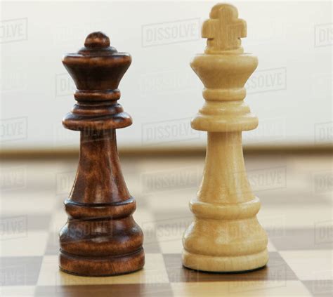 Opposing king and queen chess pieces - Stock Photo - Dissolve