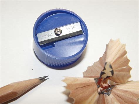 a pencil and sharpener sitting on top of a table next to some pencils