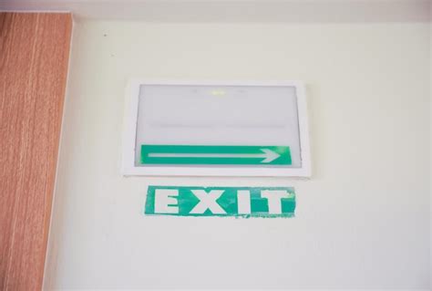 Premium Photo | A green exit sign on a wall with a white sign that says exit.