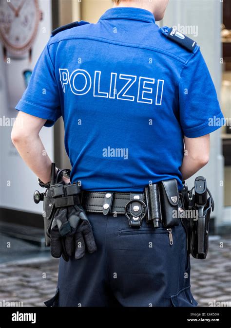 Female Swiss police officer in uniform with equipment, from behind ...