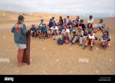 NAMIBIA Tourists sand surfing Stock Photo - Alamy