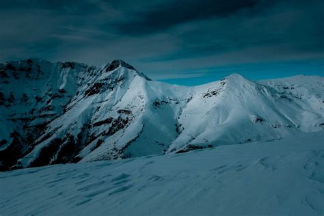 Snow Covered Mountain Under Cloudy Sky · Free Stock Photo