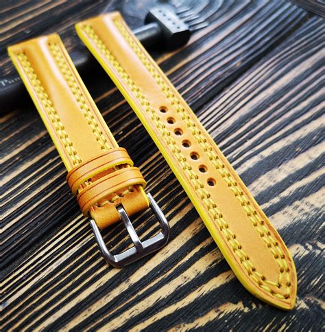a yellow leather watch strap sitting on top of a wooden table