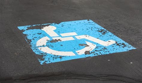 Premium Photo | Blue handicap parking symbol against asphalt background representing accessible ...