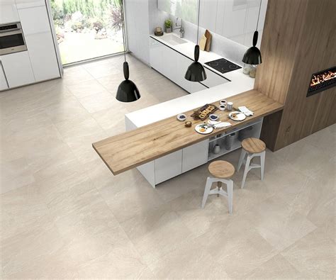 an aerial view of a modern kitchen and dining area with white cabinets, counter tops, and stools