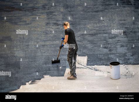 Construction site, application of a bituminous coating on a concrete ceiling, preparation for ...