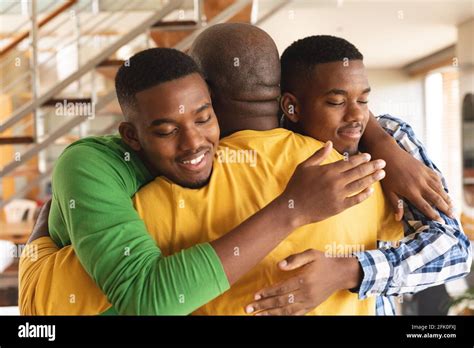 African american senior man and his two sons hugging each other at home Stock Photo - Alamy