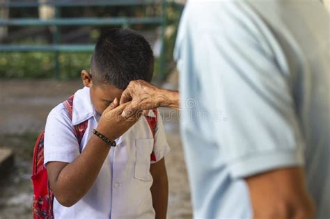 A Young School Boy Pays Respect To His Grandfather by Doing the Mano Po ...