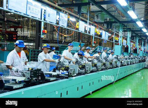 Chinese factory workers assemble motorcycles on the assembly line at the plant of Sundiro Honda ...