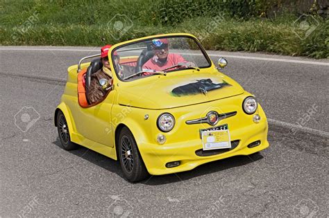 20390360-a-yellow-vintage-tuned-car-fiat-500-abarth-roadster-running-in ...