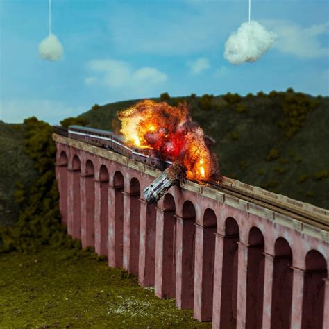 a train that is on top of a bridge with fire coming out of the engine