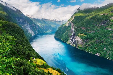 The steep mountainsides of Sunnylvsfjorden in Norway frame the cold turquoise water whose ...