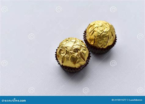 Round Chocolate Candies in a Gold Wrapper on a White Background Stock ...