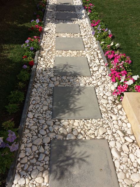 Cement block tiles bordered by white pebbles for a simple pathway | Small front yard landscaping ...