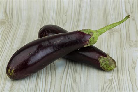 Aubergine on wooden background 12060866 Stock Photo at Vecteezy