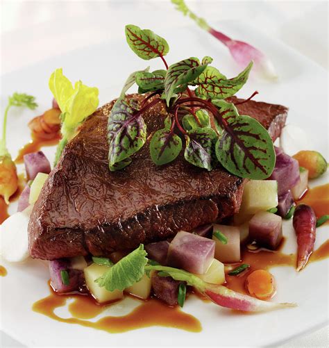 Broiled Flap Steak On A Bed Of Root Vegetables And Demi Glaze With Red Veined Sorrel Garnish ...