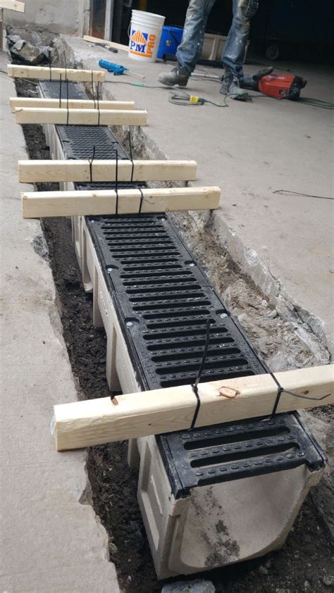 Installation of drains in a commercial parking lot. | Backyard drainage ...