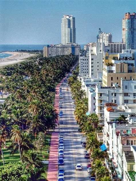 an aerial view of a city street with tall buildings and palm trees on both sides