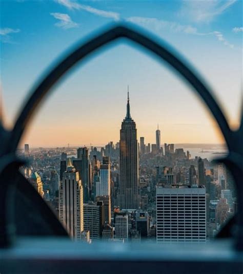 the city skyline is seen through an iron fence with a view of ...