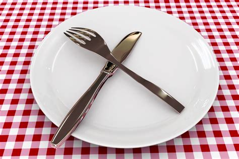 Spoon And Fork On Plate Over The Table Shows Food Stock Photo