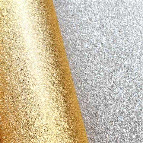 an up close view of the gold fabric on a white background with silver and yellow colors