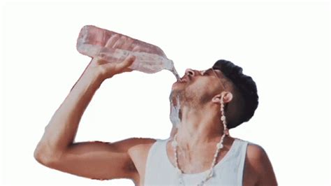 a man drinking water from a plastic bottle