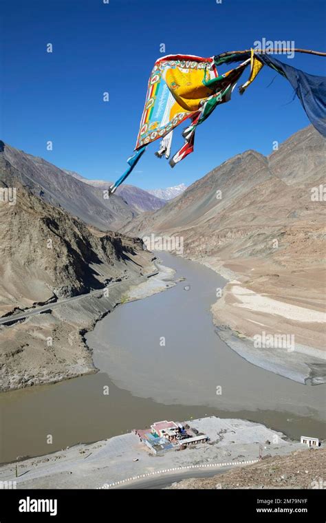 Confluence of the Indus and Zanskar rivers in the Himalayas, prayer flag in front, Indus Valley ...