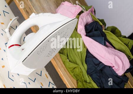 Iron and a big heap of messy, crumpled clothes Stock Photo - Alamy