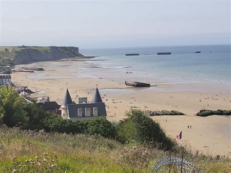 Arromanches beach with remnants of WWII D-Day artificial Mulberry harbor, "Port Winston ...