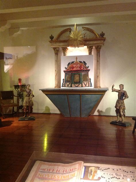 a room with wooden floors and statues on display