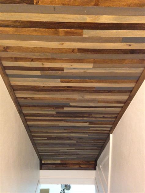 Ceiling above basement stairs. Used wood lath strips to create a reclaimed wood type look. Wood ...