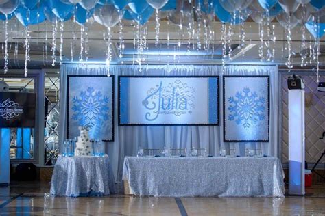 a table set up for a party with balloons and snowflakes
