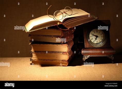 Vintage still life with old books and spectacles near clock Stock Photo ...