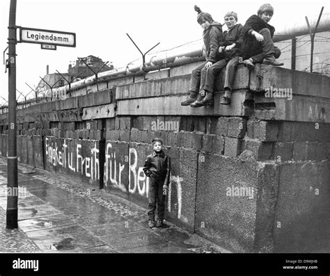 A group of children sits on the Berlin Wall at the 'Legiendamm' in the West Berlin borough ...