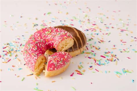 Premium Photo | Delicious frosted donuts with colorful sprinkles thrown around