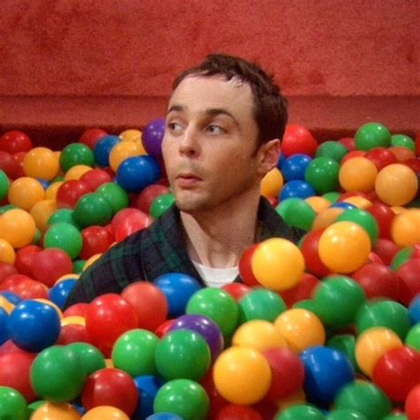 a man in a ball pit looking up at the camera