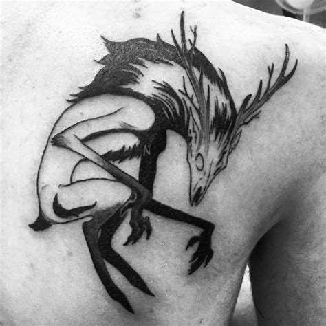 the back of a man's shoulder with an artistic tattoo design on his chest