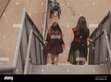 back view of two young women walking down the stairs Stock Photo - Alamy