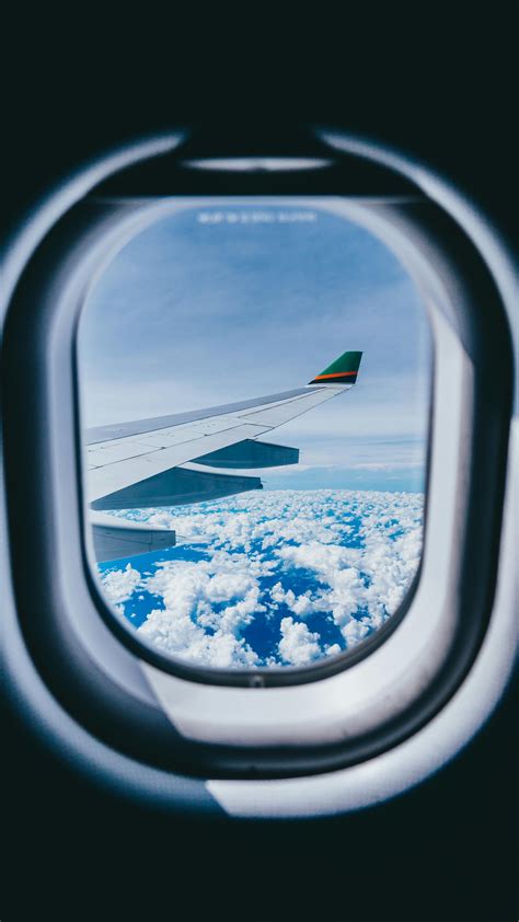 Airplane Window View of Airplane Wing and Clouds · Free Stock Photo