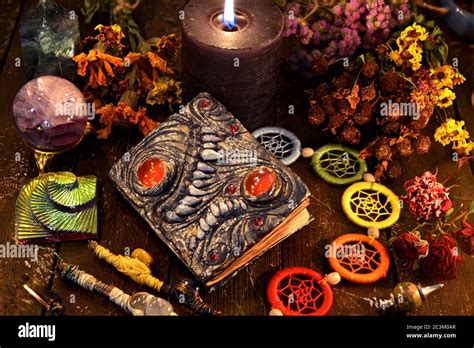 Witch grimoire with black candle, herbs and chakra decorations. Wicca ...