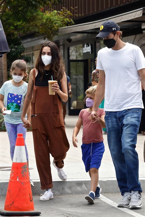 Mila Kunis and Ashton Kutcher walk hand in hand with their kids during a trip to Erewhon Market ...