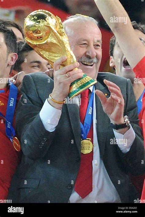 Spain's coach Vicente del Bosque (C) lifts the World Cup trophy after the 2010 FIFA World Cup ...