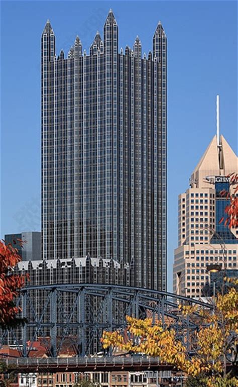 the tall buildings are next to each other in front of trees with fall leaves on them