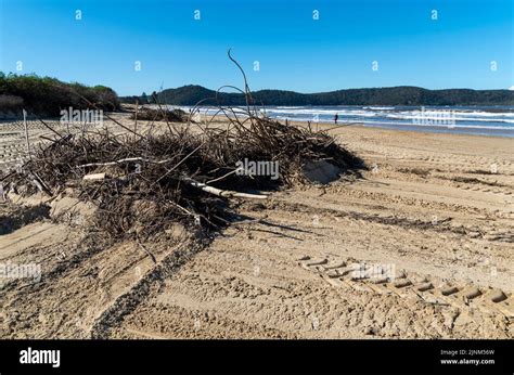 Woy Woy, Australia - July 8 2022: Contractors were clering up debris on the beaches along the ...