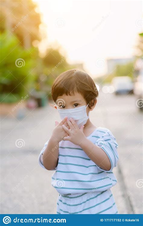 Child Wearing a Protective Face Mask on a City Street with Air ...