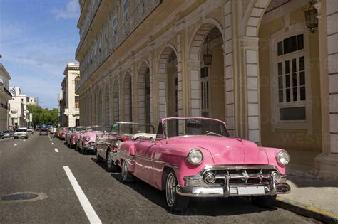 Pink vintage cars parked in city on sunny day stock photo