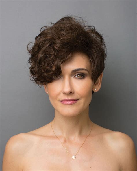 Dramatic tapered and asymmetric style with curly layers that gradually fall to the side of the ...