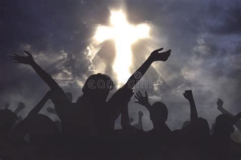 silhouettes of people raising their hands in front of a cross on a ...