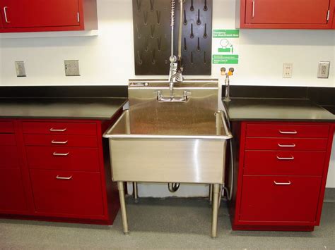 a stainless steel sink in a kitchen with red cabinets