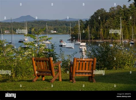 Two wood chairs on overlook view to boats moored in cove in late summer at Lake Champlain Yacht ...